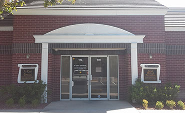 The image shows a building entrance with a brick facade, a white pillar, and a sign that reads  Santa Rosa Medical Center.