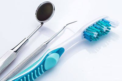 Dental tools and a toothbrush on a white background.