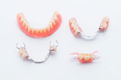 The image displays a collection of dental braces with missing teeth, arranged in two rows.